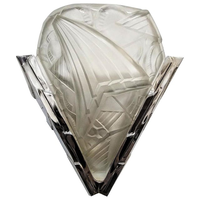 A pair of French Art Deco wall sconces by the French artist "H. Mouynet". Molded clear frosted glass shades decorated in a...