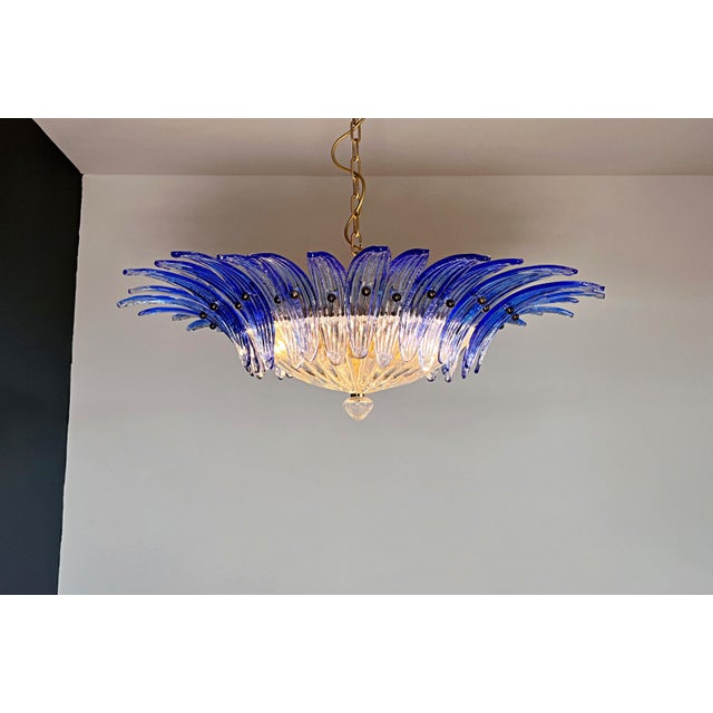 Luxury and genuine murano glass chandelier. Hand made in murano. It made by 36 murano blue glasses in a gold painted metal...