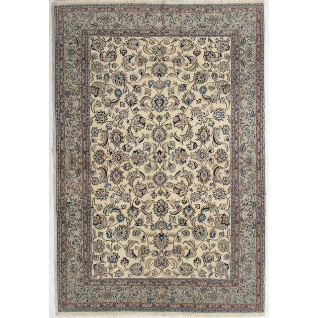 Antique hand-knotted Persian Mashad wool rug with an ivory field featuring a finely drawn allover floral pattern of...