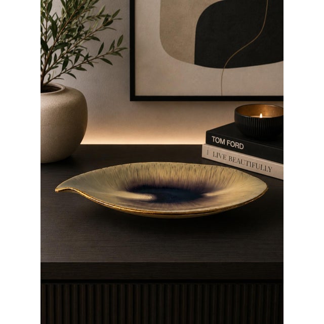 A sculptural mid-century West German pottery dish in an elegant elongated leaf form, finished in a deep brown-to-black...