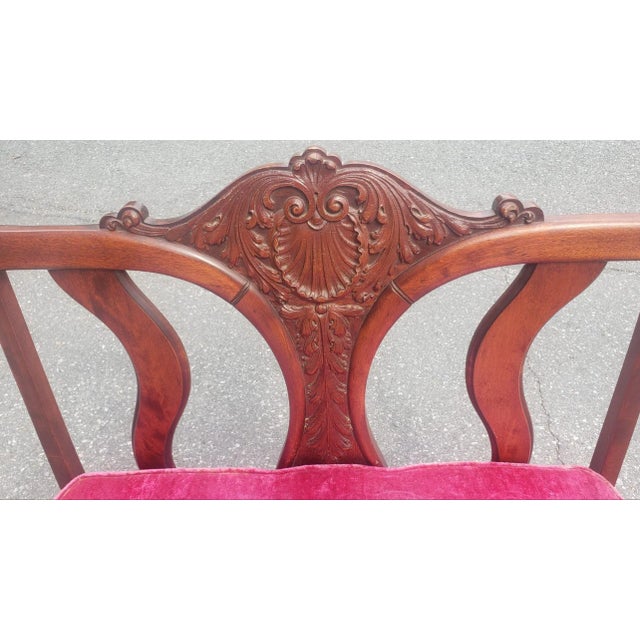 An Early 20th Century Victorian Style Carved Mahogany and Upholstered Settee with impressive center back carving. Measures...