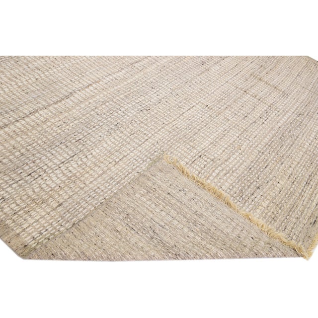 Beautiful modern Moroccan style hand-knotted wool rug with a beige and light brown field. This piece has a gorgeous subtle...