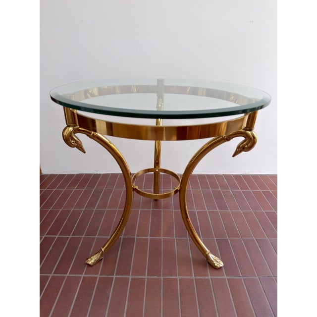 Beautiful vintage Hollywood Regency brass and glass side table, circa 1960s / 1970s. The sculptural brass base features...