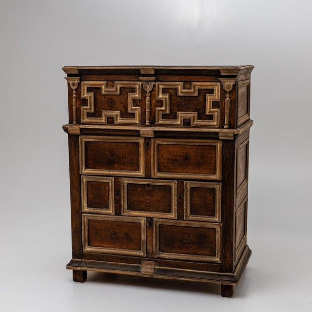 English chest of drawers with four drawers and paneled fronts and sides. The surfaces are structured with profiled...