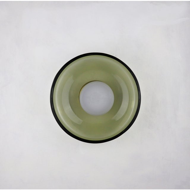 This small wall light is crafted from hand-blown glass, offering a delicate yet expressive presence. Its compact scale...