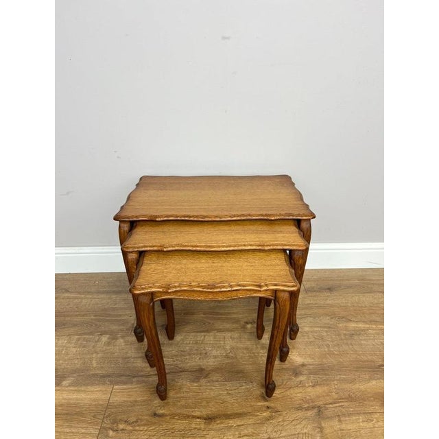 An elegant Vintage French Louis nest of three tables , featuring graceful shaped tops, decorative carved edging and...