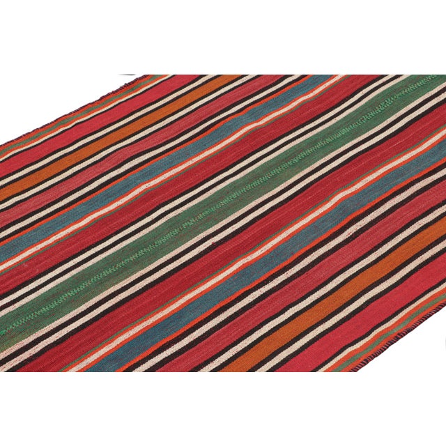 This vintage 5x10 Persian kilim is a mid-century tribal rug, handwoven in wool circa 1950-1960. The design enjoys stripes...