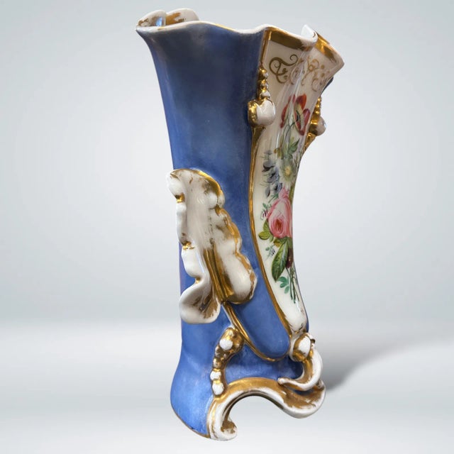 An Old Paris Porcelain Vase with a floral centerpiece theme and gilt detailing. 19th Century. As is typical with Old...
