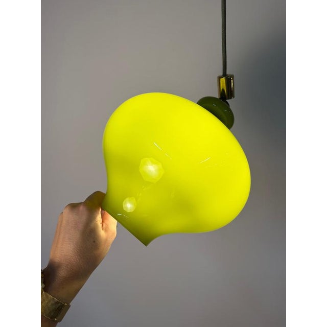 A masterpiece of Scandinavian-German lighting design: This green glass pendant lamp combines the poetic vision of Swedish...