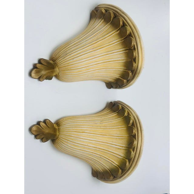 Elegant pair of vintage ceramic wall pockets featuring a graceful shell-inspired design with deeply fluted detailing and a...