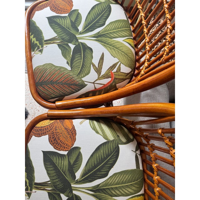 A rare matched set of 2 vintage rattan swivel bar stools, each custom upholstered in a lush tropical botanical print —...