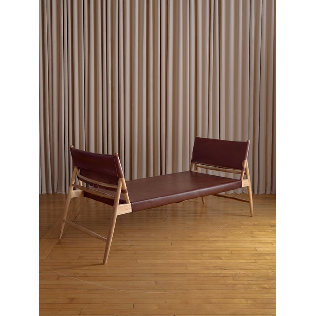 A refined and sculptural mid-century daybed featuring a leather seat paired with a beautifully refinished solid wood...