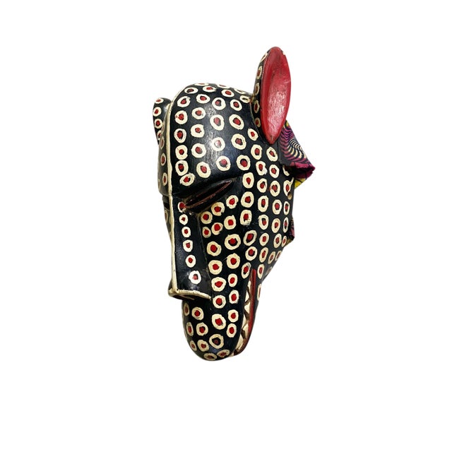 Superb Bozo Leopard mask hand carved of one piece of wood with vibrant colors . The surface displays a black ;background...
