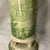 This is a green toile transferware footed ceramic vase featuring classic pastoral and architectural vignettes.