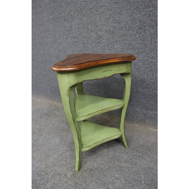Compact Baker Furniture corner side table featuring a softly distressed sage green painted finish and shaped cherry top....