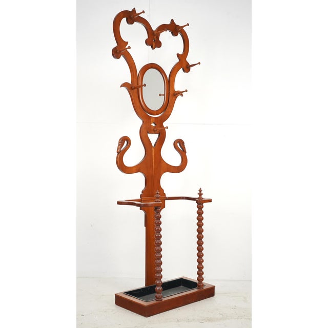 Victorian fruit wood entryway hall tree with eight long wood peg hooks, a tilting mirror, and an umbrella stand with a...