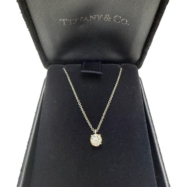 An exquisite Tiffany & Co. pendant necklace showcasing a vibrant round brilliant cut diamond weighing 0.44 carat with F...