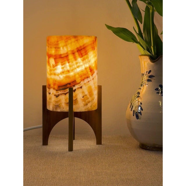 Comet pairs a hand-carved Egyptian alabaster shade with a geometric walnut base, combining contemporary form with...