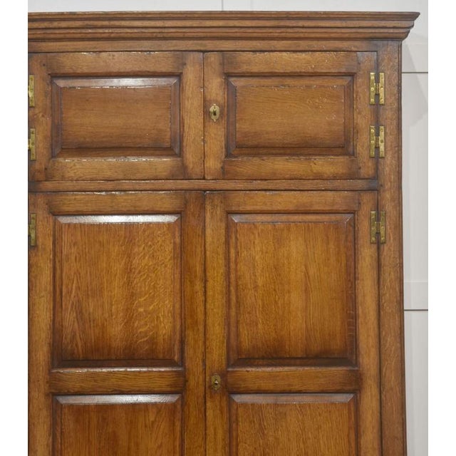 This substantial early-20th-century oak hall seat cupboard presents an impressive blend of utility and traditional...