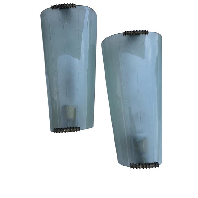 Curved and satin glass sheet with brass finishes that act as a support with a decorative motif. This piece is designed in...