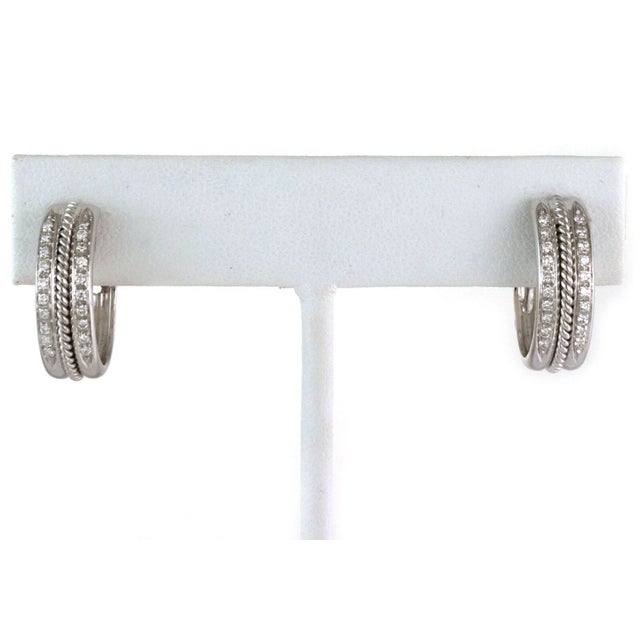 Crafted to exude timeless elegance, these Diamond 18k White Gold Oval Hoop Earrings are a testament to classic fine...