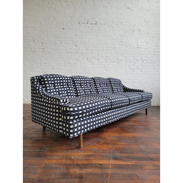 Classy mid-century modern sofa circa 1960s with an elegant silhouette, scalloped back and sloping arms. A lovely balance...