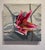 This oil painting features a vibrant stargazer lily emerging from a crumpled white package, creating a striking contrast...