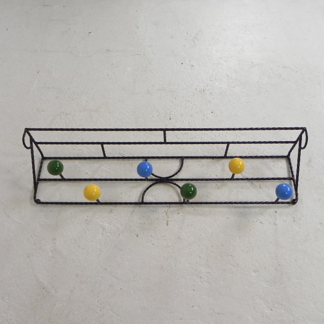 This coat rack is constructed from a frame of turned steel profile. The spheres are made of wood and have been repainted...