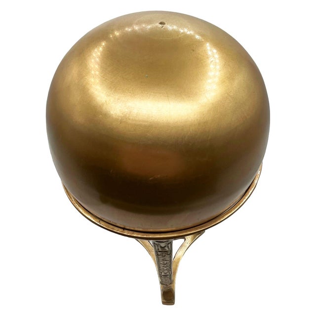 Elegant Art Nouveau brass orb or witches ball featuring a smooth domed lid, decorative cast floral and ribbon motifs, and...