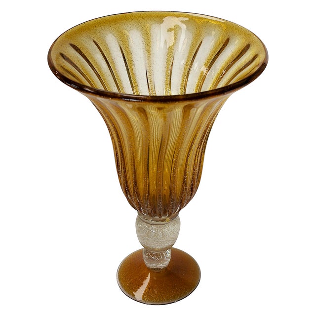 Large Italian handmade vase is made of yellow / amber color Murano glass with inlaid gold/silver dust and white leg. This...