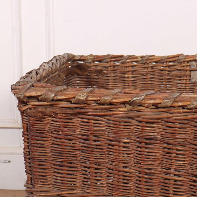 1920's Country house log basket with leather banding, rope handles and wheels underneath. 1920 This piece is designed in...