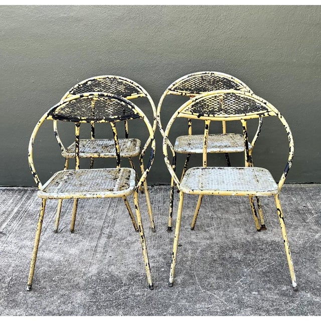 This vintage mid-century modern hoop-back folding chair set showcases a distinctly sculptural silhouette, with continuous,...