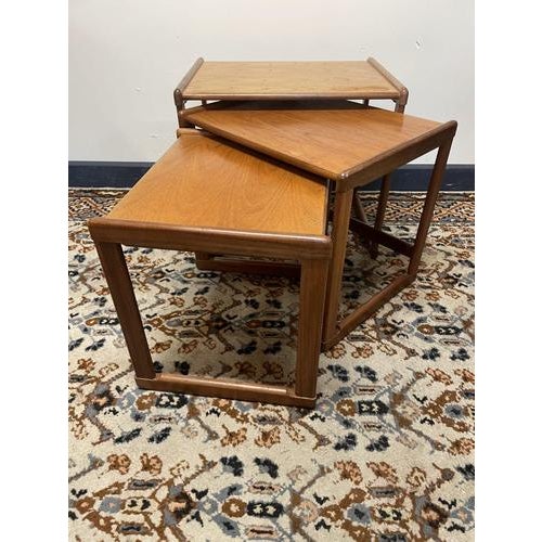 A stylish and functional set of three Danish modern nesting tables in richly grained teak, c.1960s. Clean lines, gentle...