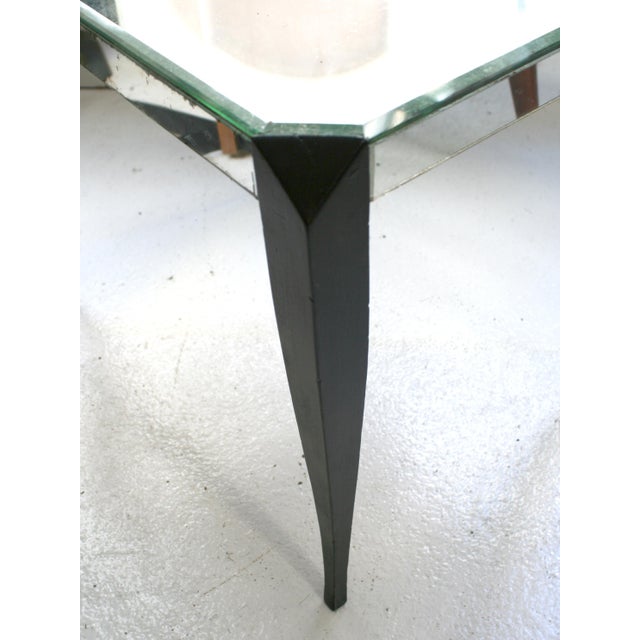 A 1940s French table. Made of mirror glass, with black-tinged wooden legs. It can be used as a sidetable or a bedside table.