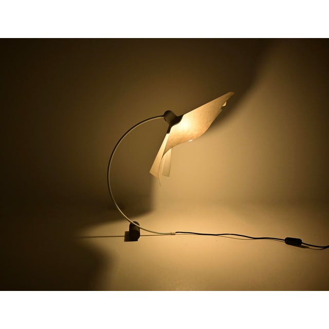 Beautiful white metal and paper table lamp by Mario Bellini. The adjustable shade allows you to direct the light in...