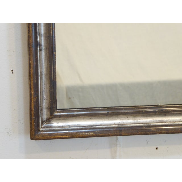 This silverleaf mirror with pewter tones, has brighter silver in the cove and measures 27.75"H x 21.75"W.