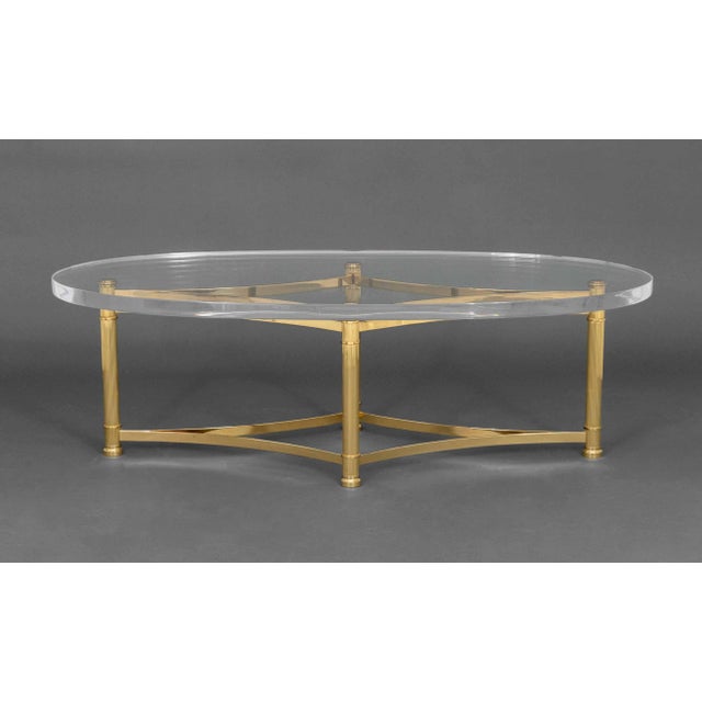 Modern Brass and Acrylic Oval Coffee Table, the base with four fluted columns conjoined by diamond form stretcher. 17" H x...