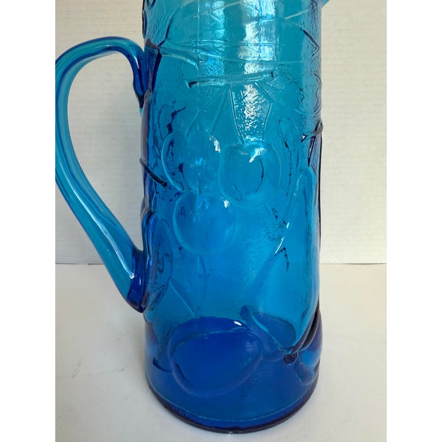 Here is a vintage Italian art glass pitcher, likely dating to the 1960s–1970s, in a vibrant cobalt blue with a molded...