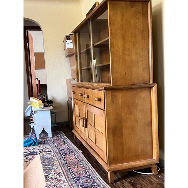 Impressive early mid-century modern display cabinet with glass doors from 1958. There is a distinctly late 1950's American...