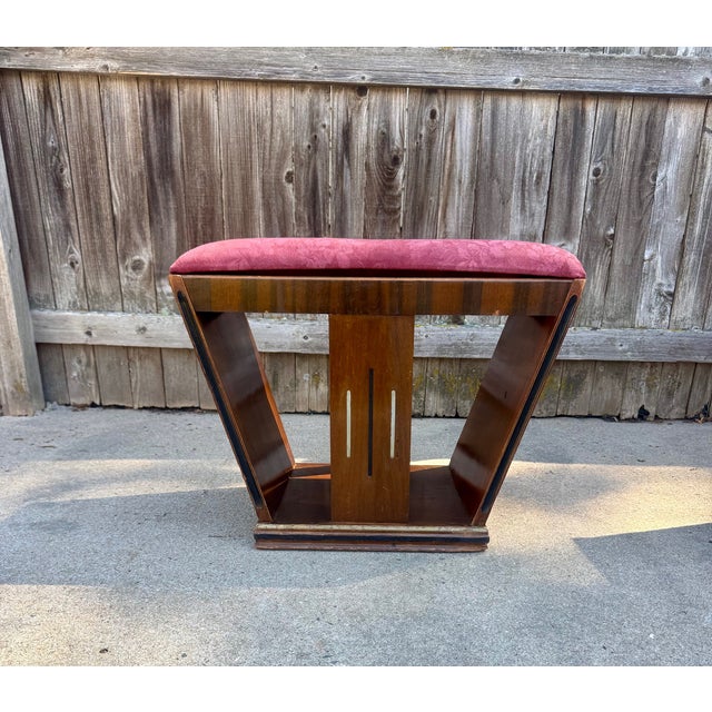 Elegant vintage vanity stool featuring a sculptural Art Deco silhouette with dramatic sloped sides and rich bookmatched...