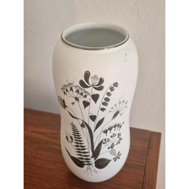 A decorative stoneware vase with silver decor, depicting a flower bouquet. Designed by the artistic leader of Gustavsberg...