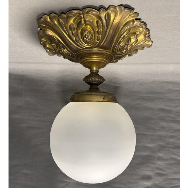 Art Nouveau brass ceiling lamp with original fire patina and glass globe, circa 1910, possibly from Paris, France. Brass...
