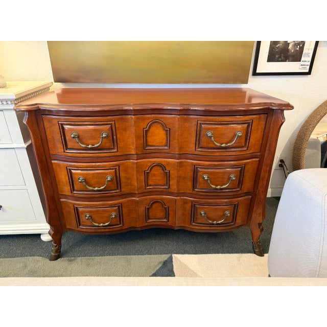 Design Plus Gallery presents a French Provincial Louis XV Style Chest of Drawers from Baker Furniture. The chest has a...