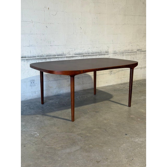 This elegant dining table features a minimalist rectangular profile. The streamlined silhouette showcases classic...