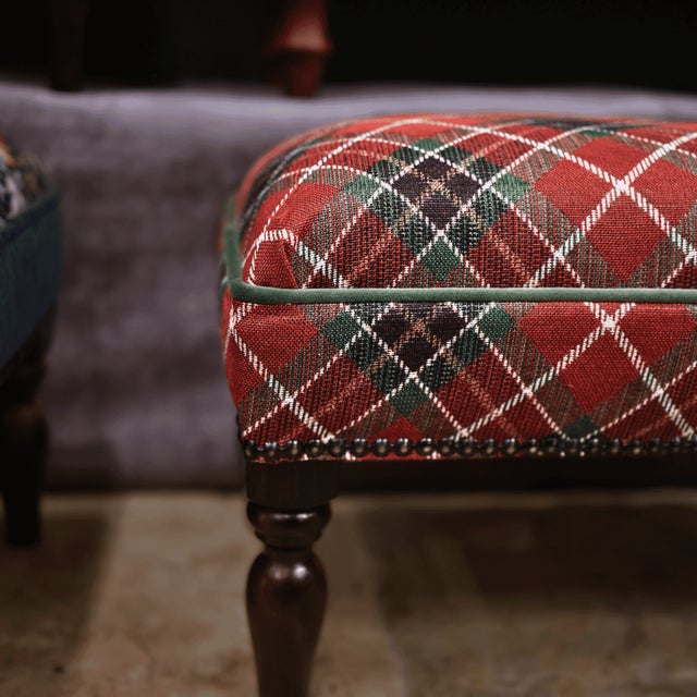 Meticulously handcrafted in the United Kingdom, this upholstered stool boasts classic studding and hand-polished solid...
