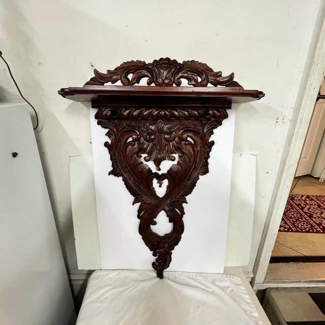 Hand Carved mahogany coat / hat rack with top shelf. 3 pegs available for hanging. Lovely ornate design. Reproduction of...
