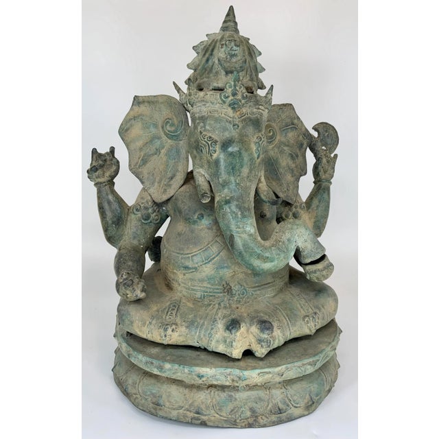 Antique Javanese style bronze seated Ganesha from Indonesia. Ganesha is seated on a double lotus flower circular base. The...