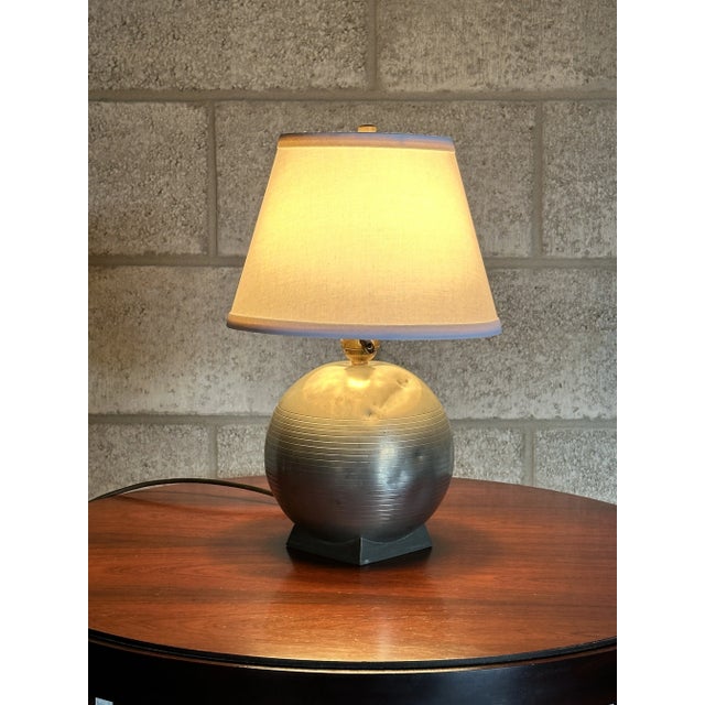 A wonderful and whimsical table lamp designed by GAB Sweden (Guldsmedsaktiebolaget). Features a round spherical body on a...