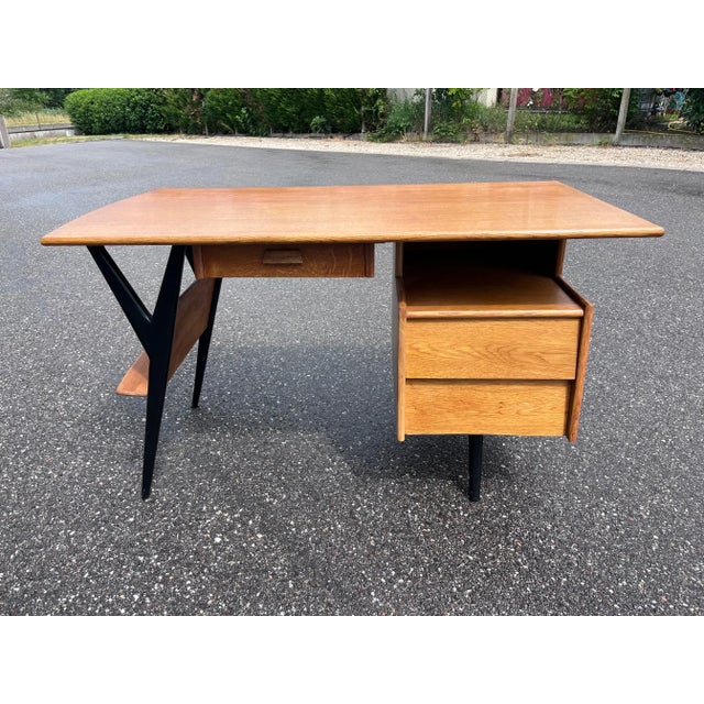 Magnificent desk by Louis Paolozzi Guermonprez edition from the 1950s. Quality finishes: airplane wing top, solid oak...