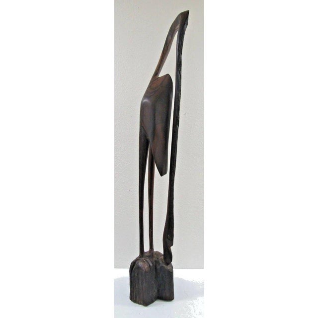 African Tall Slender Wooden Crane Sculpture attributed to Bunmi Babatunde Measures 6 1/4" wide, 7 1/2" deep and 47" tall....